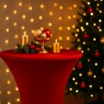 Rote Stehtischhusse mit goldenen Weihnachtsdekorationen und Kerzen vor festlichem Lichterhintergrund