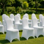 Reihenweise aufgestellte Stühle mit Stuhlhussen in einem gepflegten Garten.